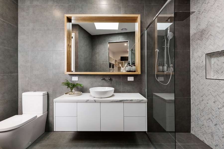 Modern bathroom interior featuring sleek dark grey floor tiles and a floating vanity.